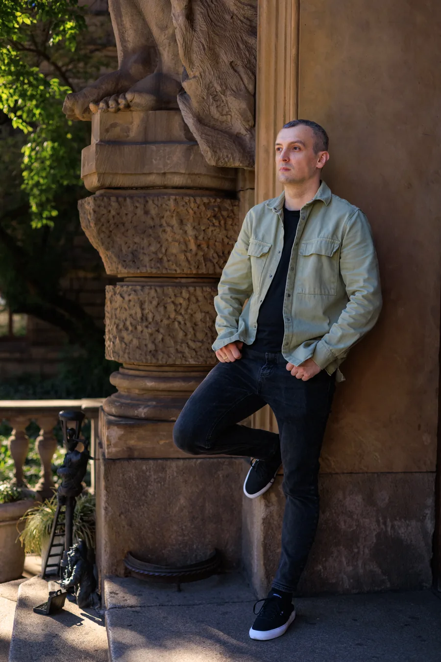 Yaroslav Volkov leaning beside a carved stone column outdoors.